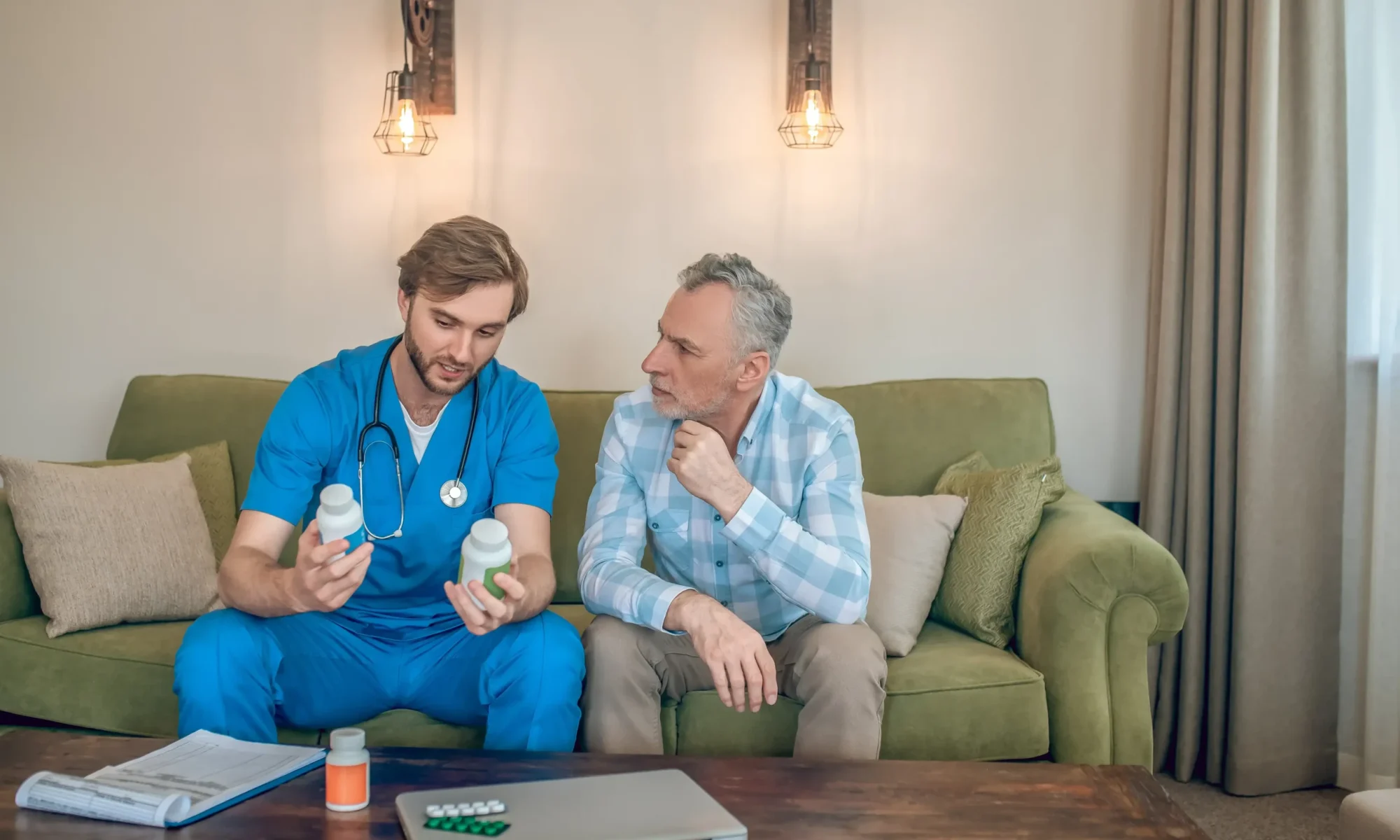 front-view-young-doctor-with-plastic-vitamin-bottles-his-hands-talking-mature-man (1) (1) (1)